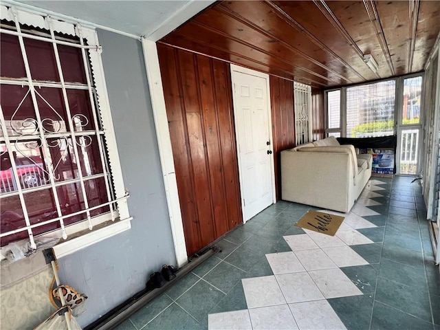 hall featuring wooden walls and wooden ceiling