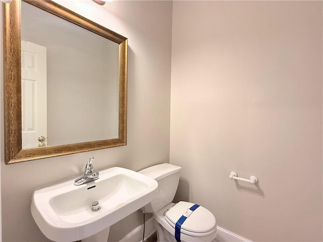 half bathroom featuring a sink and toilet