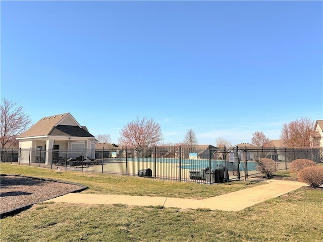 view of home's community with a pool, a yard, and fence