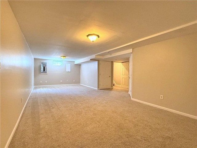 below grade area featuring baseboards and light colored carpet