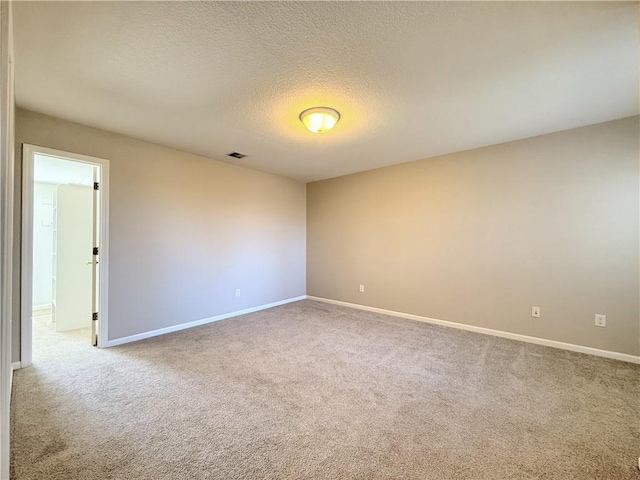 carpeted empty room featuring visible vents, baseboards, and a textured ceiling