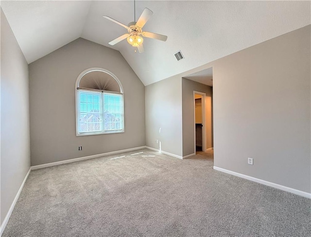spare room featuring visible vents, baseboards, carpet, ceiling fan, and vaulted ceiling
