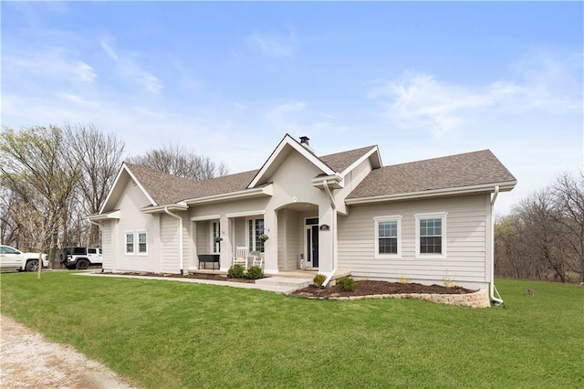 view of front of home featuring a porch, a front lawn, and roof with shingles
