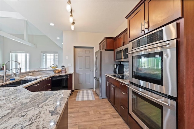 kitchen featuring a sink, black appliances, light wood-style flooring, light stone countertops, and recessed lighting