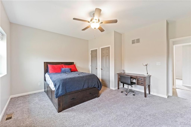 carpeted bedroom with visible vents, a ceiling fan, and baseboards
