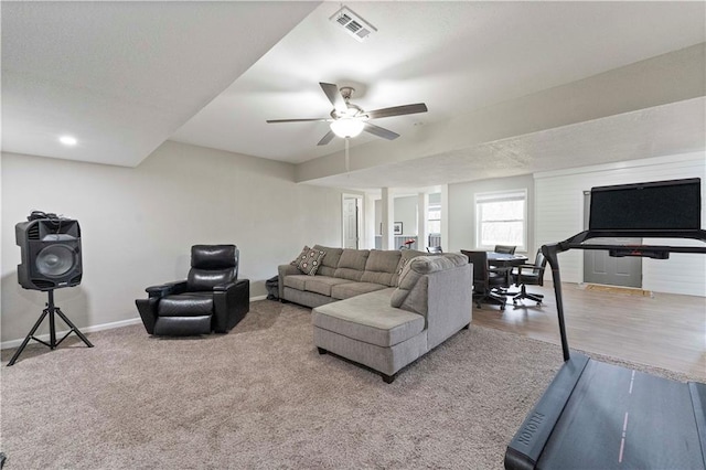 living room featuring baseboards, a ceiling fan, and visible vents