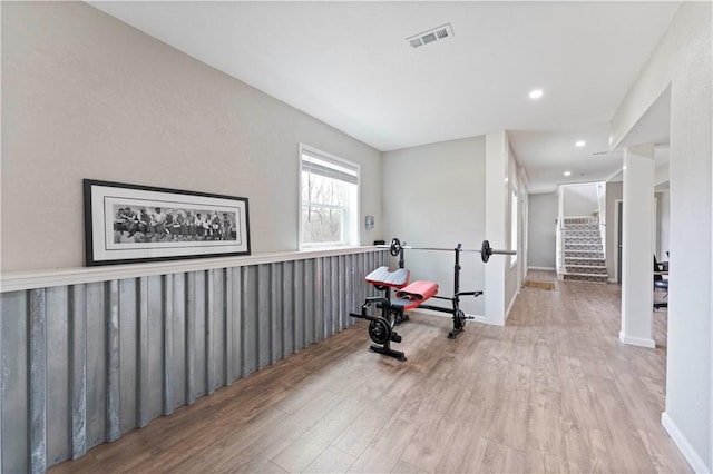 exercise area featuring baseboards, wood finished floors, visible vents, and recessed lighting