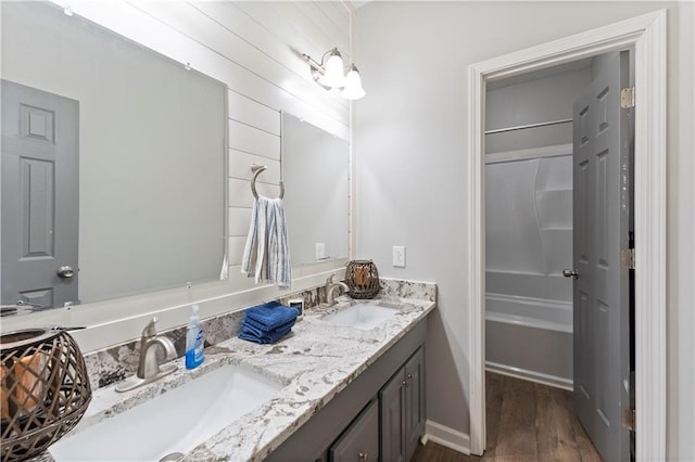 full bathroom featuring shower / bath combination, wood finished floors, a sink, and double vanity