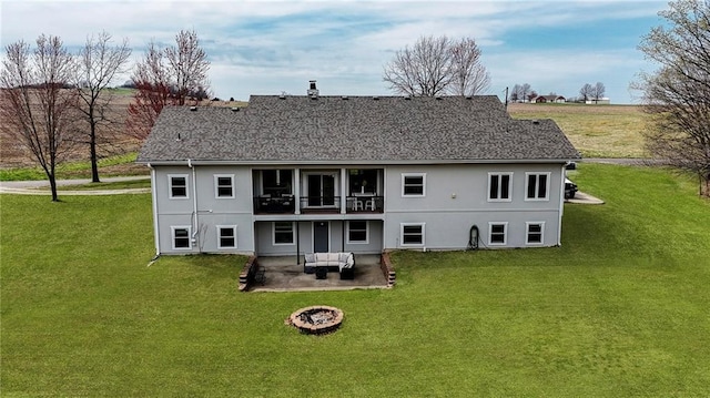 rear view of house featuring a lawn, a balcony, an outdoor living space with a fire pit, and a patio