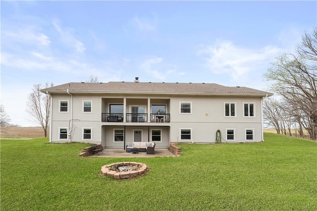 back of house with a yard, an outdoor living space with a fire pit, and a patio