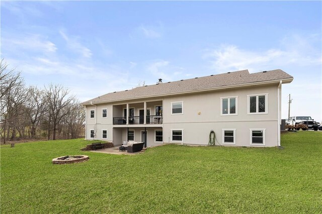 back of house featuring a fire pit, a yard, a patio area, and stucco siding