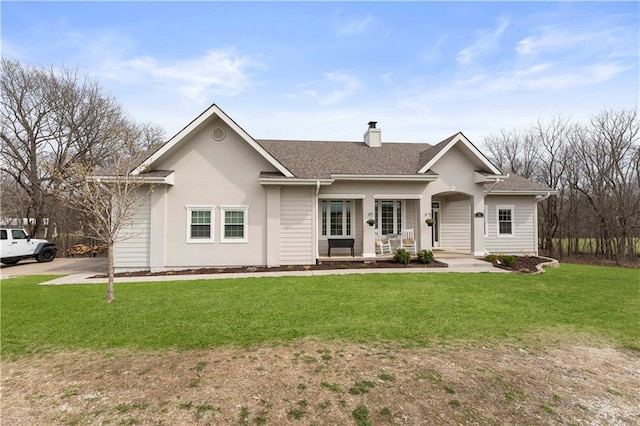 ranch-style house featuring a chimney, a front yard, covered porch, and a shingled roof