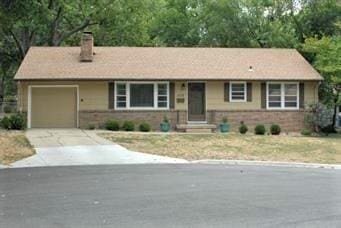 ranch-style house featuring a chimney, concrete driveway, entry steps, and an attached garage