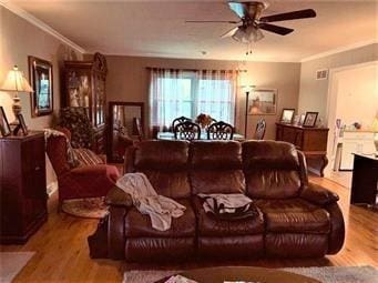 living room with crown molding, wood finished floors, and a ceiling fan