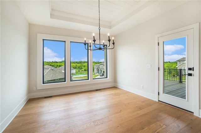 2317 SW Morris Dr, Lees Summit, MO 64082 - unfurnished dining area with a raised ceiling, a chandelier, light wood-style floors, baseboards, and crown molding