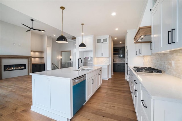 2317 SW Morris Dr, Lees Summit, MO 64082 - kitchen with a sink, dishwashing machine, stainless steel gas cooktop, backsplash, and a glass covered fireplace
