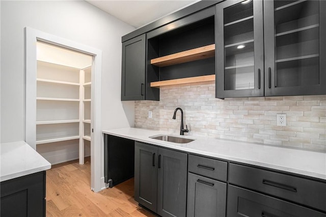 2317 SW Morris Dr, Lees Summit, MO 64082 - kitchen with a sink, light wood-style floors, tasteful backsplash, light countertops, and open shelves