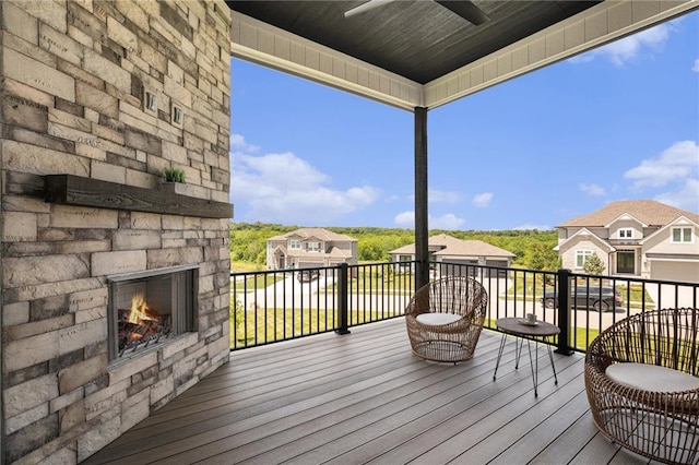 2317 SW Morris Dr, Lees Summit, MO 64082 - wooden terrace with an outdoor stone fireplace, a ceiling fan, and a residential view
