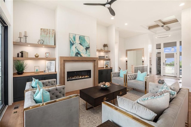 2317 SW Morris Dr, Lees Summit, MO 64082 - living area featuring wood finished floors, ceiling fan, coffered ceiling, a glass covered fireplace, and recessed lighting