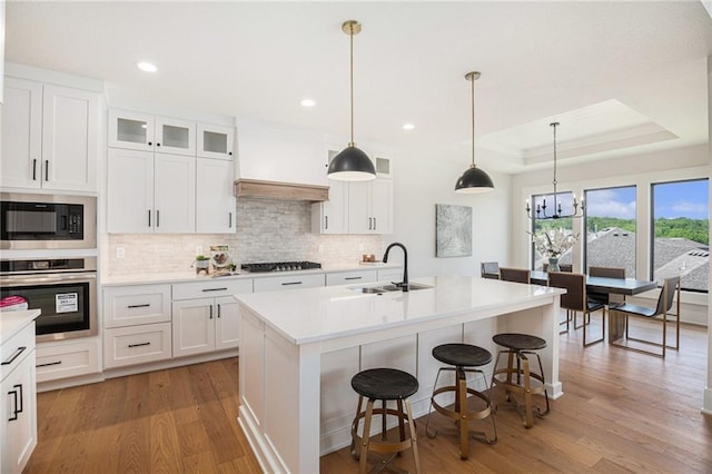 2317 SW Morris Dr, Lees Summit, MO 64082 - kitchen with oven, built in microwave, wood finished floors, backsplash, and a kitchen bar