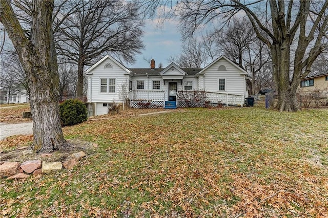 view of front of house with a chimney and a front lawn