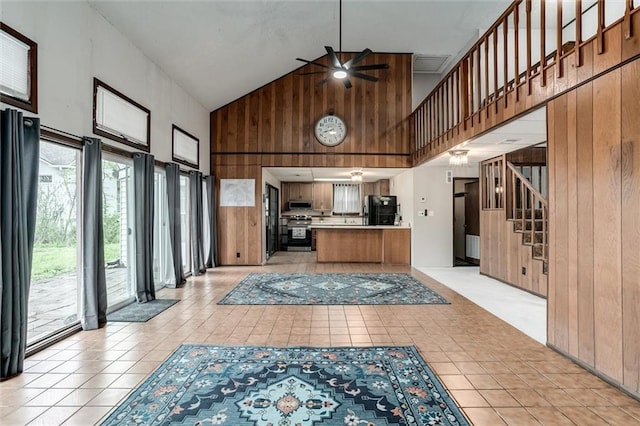 134 Timber Valley Dr, Linn Valley, KS 66040 - interior space featuring wooden walls, a ceiling fan, high vaulted ceiling, and light tile patterned floors