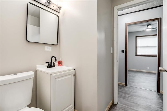 134 Timber Valley Dr, Linn Valley, KS 66040 - half bathroom featuring vanity, wood finished floors, toilet, baseboards, and ceiling fan