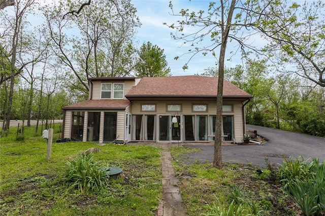 134 Timber Valley Dr, Linn Valley, KS 66040 - back of property with a sunroom, a shingled roof, a yard, and driveway