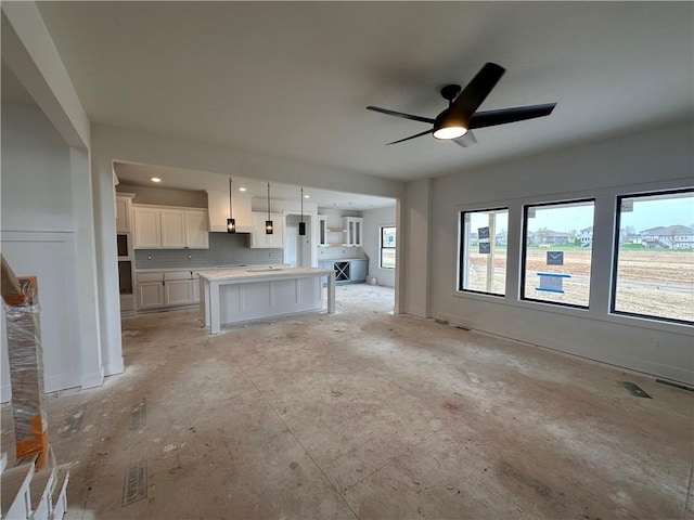 unfurnished living room with ceiling fan and visible vents