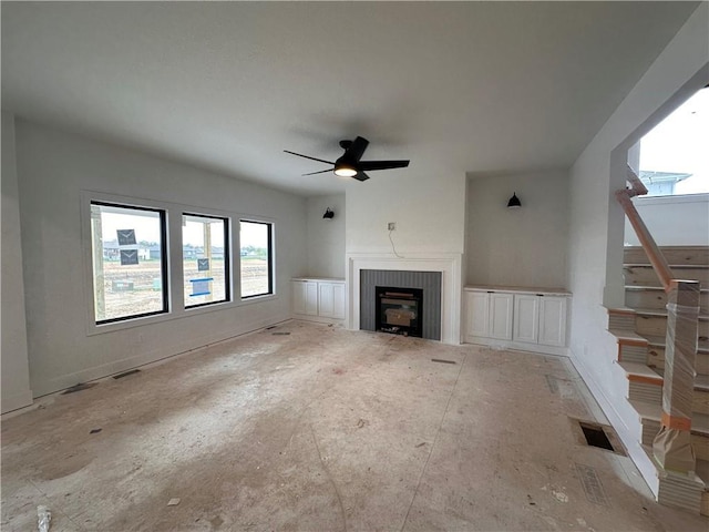 unfurnished living room featuring visible vents, ceiling fan, baseboards, and a fireplace