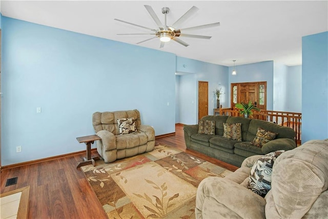 living area featuring visible vents, baseboards, a ceiling fan, and wood finished floors