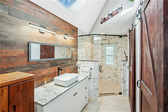 bathroom featuring a shower stall, wooden walls, vanity, and vaulted ceiling