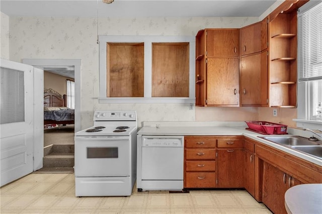 208 E 5th St, Carrollton, MO 64633 - kitchen featuring brown cabinetry, light floors, white appliances, and wallpapered walls