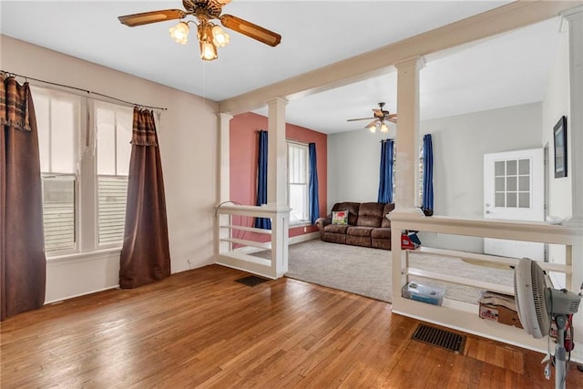 208 E 5th St, Carrollton, MO 64633 - interior space with visible vents, hardwood / wood-style floors, a ceiling fan, and ornate columns