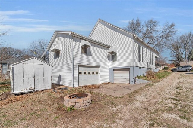 208 E 5th St, Carrollton, MO 64633 - view of side of home featuring a garage, an outbuilding, driveway, and a shed