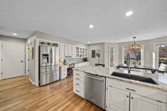 kitchen featuring a sink, appliances with stainless steel finishes, a notable chandelier, and white cabinetry