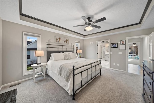 carpeted bedroom with visible vents, a textured ceiling, and a raised ceiling