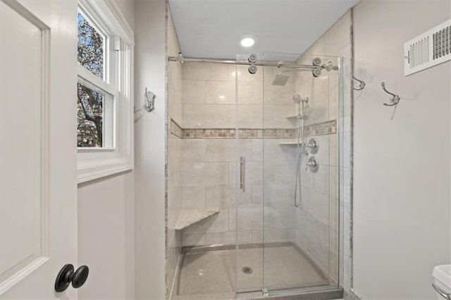 full bath with a shower stall and visible vents