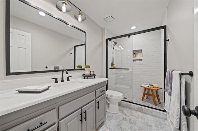bathroom featuring toilet, recessed lighting, vanity, and a stall shower