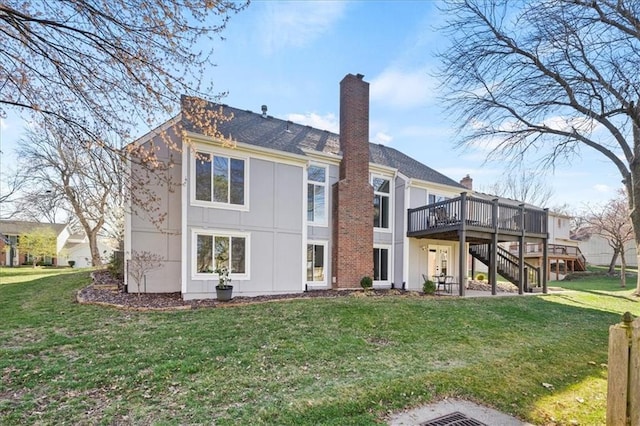 back of property with a chimney, a lawn, a deck, and stairs