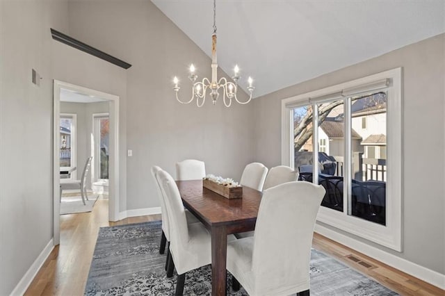 dining space featuring visible vents, baseboards, light wood finished floors, and an inviting chandelier