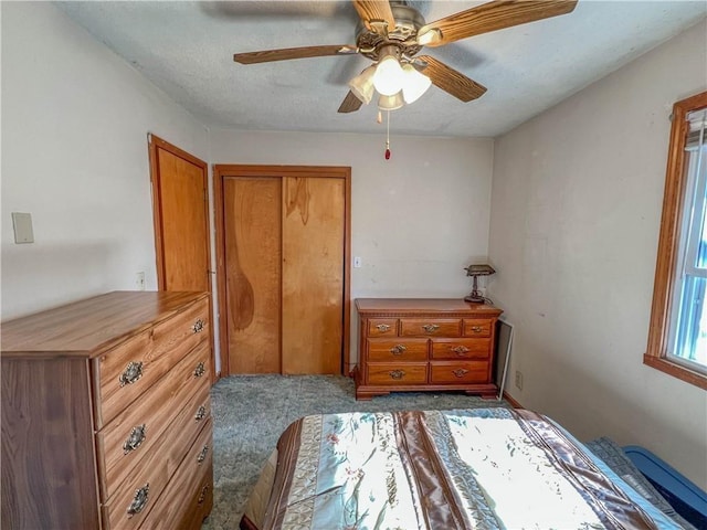 bedroom featuring ceiling fan, dark carpet, and a closet