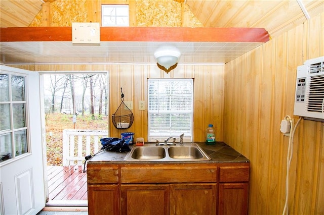 3819 Dogwood Dr, Stover, MO 65078 - kitchen featuring a sink, dark countertops, wooden walls, brown cabinetry, and lofted ceiling