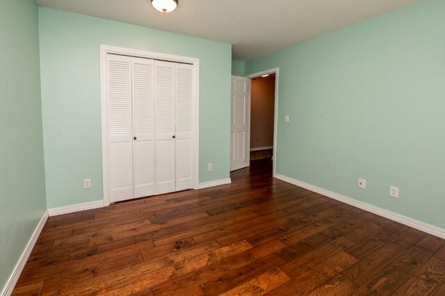 6620 NW 136th St, Kansas City, MO 64164 - unfurnished bedroom featuring a closet, baseboards, and dark wood finished floors