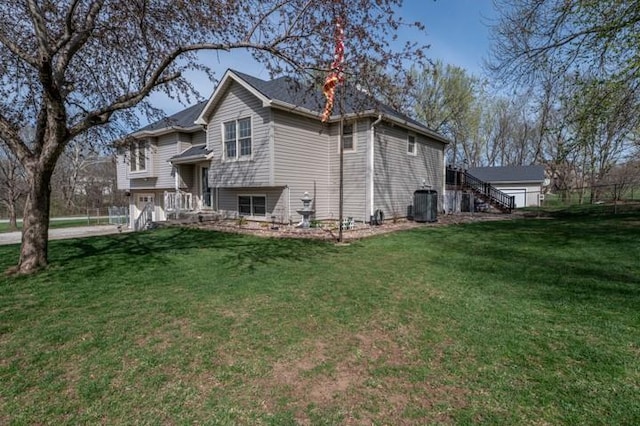 6620 NW 136th St, Kansas City, MO 64164 - rear view of house with central AC, stairway, and a lawn
