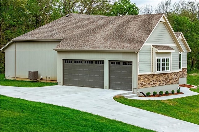 garage with central air condition unit and driveway