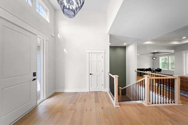 entryway with baseboards, recessed lighting, a towering ceiling, and wood finished floors