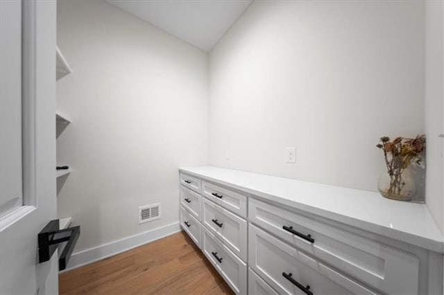 details featuring baseboards, wood finished floors, and visible vents