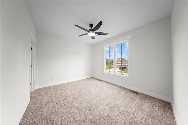 spare room with baseboards, carpet flooring, ceiling fan, and visible vents