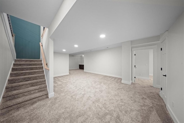 finished below grade area with carpet flooring, baseboards, and stairs